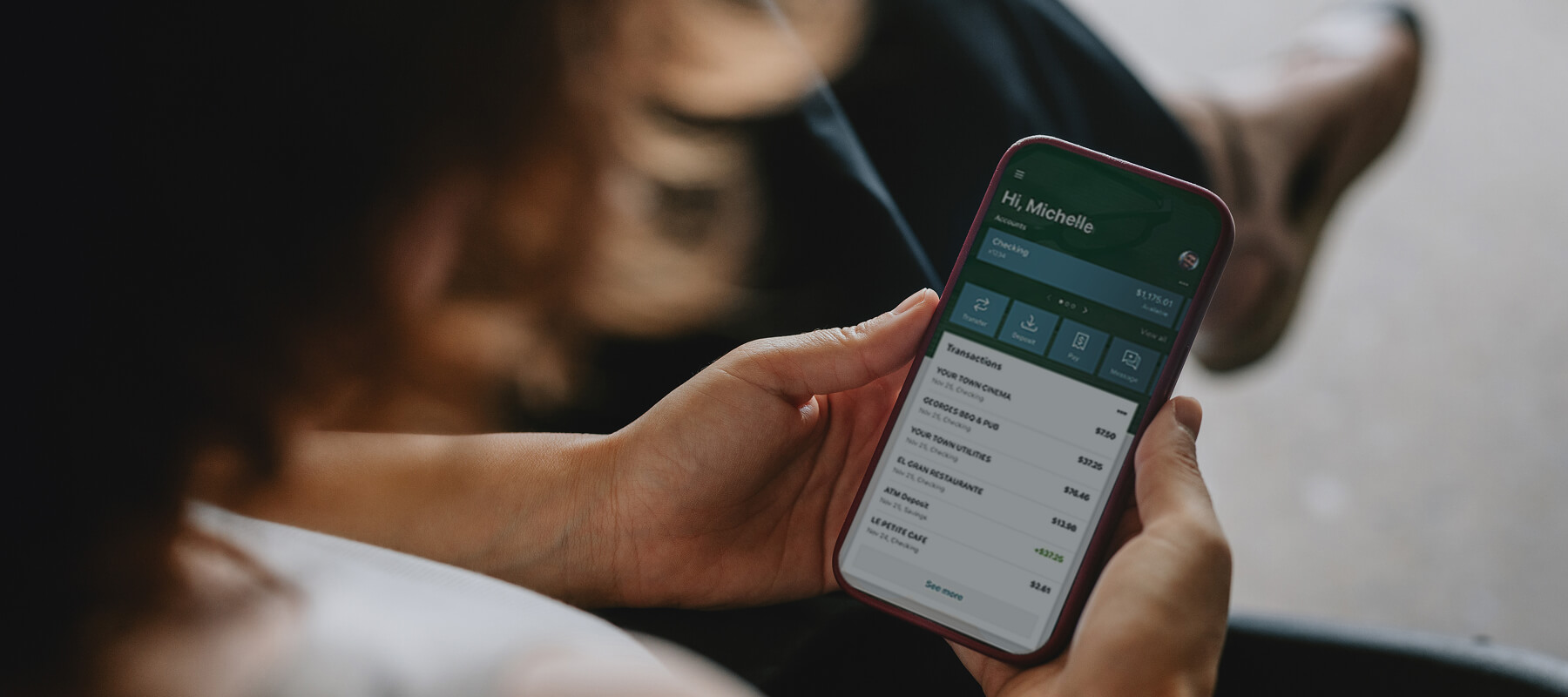 Woman holding phone with Bank Independent mobile app on screen